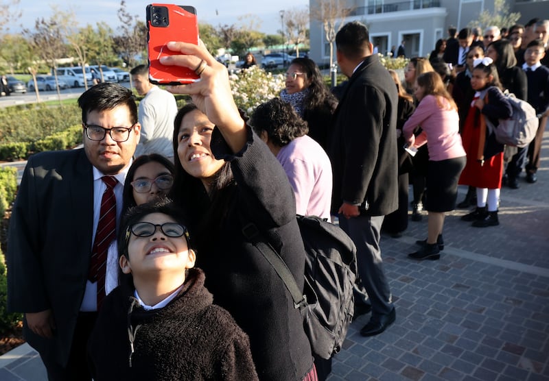 Attendees take a selfie while waiting for the dedication of the Salta Argentina Temple.