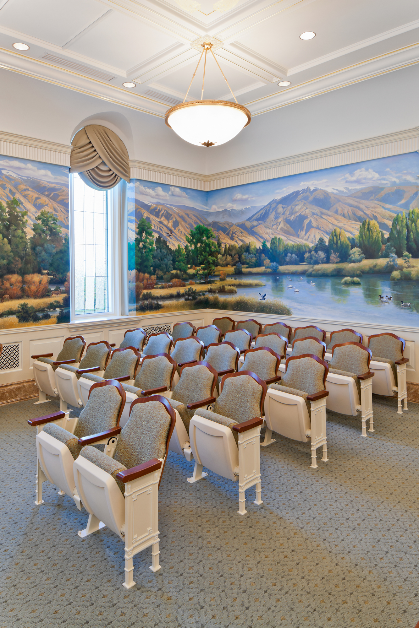 A white room with wall paintings of mountains.