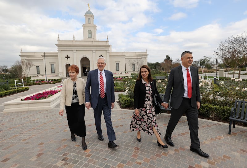 Four people walk outside the Salta Argentina Temple.