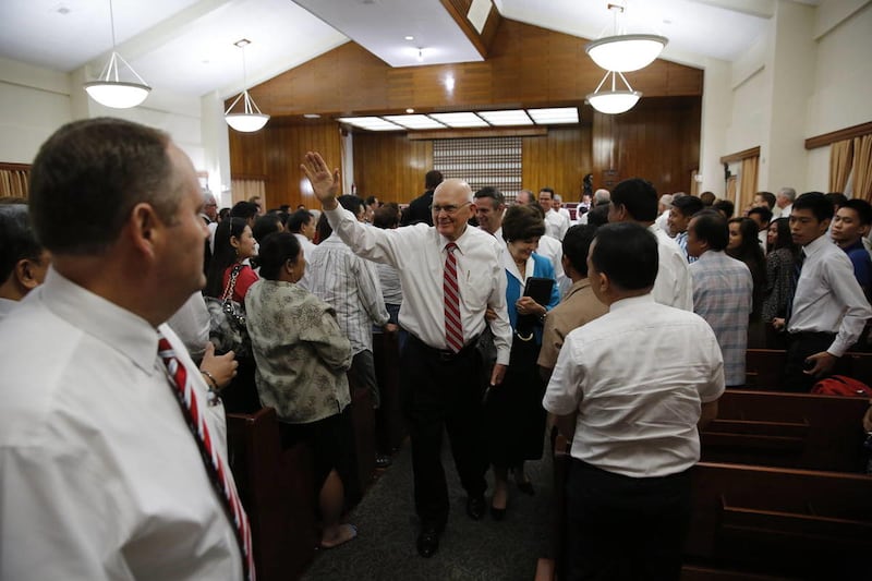 Elder Dallin H. Oaks waves as he and his wife, Sister Kristen Oaks, greet people as they leave a chapel after a meeting in the Philippines while ministering there in Oct. 23-Nov. 1, 2014.