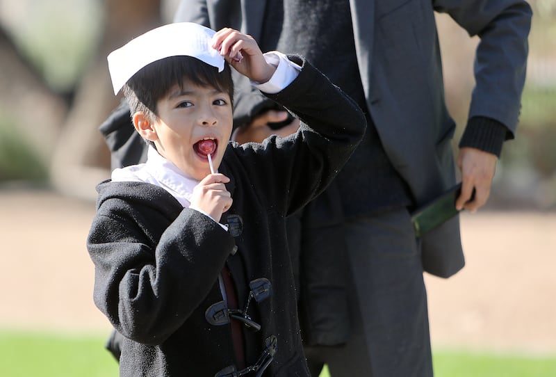 A young boy eats a lollipop.