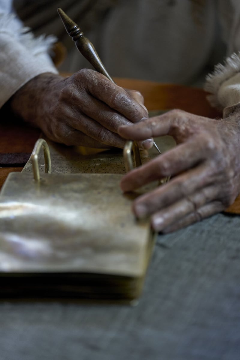 Jacob writes on metal plates in this picture from the Book of Mormon Videos.