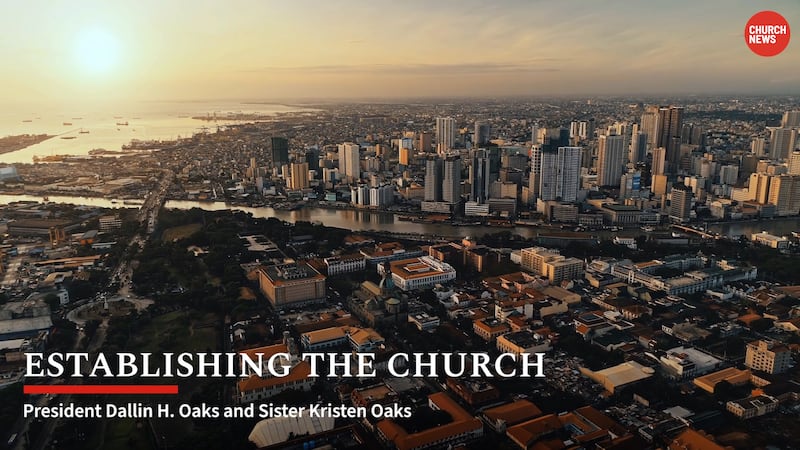 An aerial view of a city with skyscrapers, with text on the screen that says “Establishing the Church: President Dallin H. Oaks and Sister Kristen Oaks.”