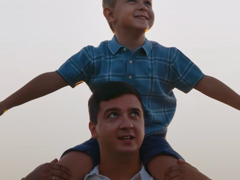 A father carries his son on his shoulders in a Father's Day video.