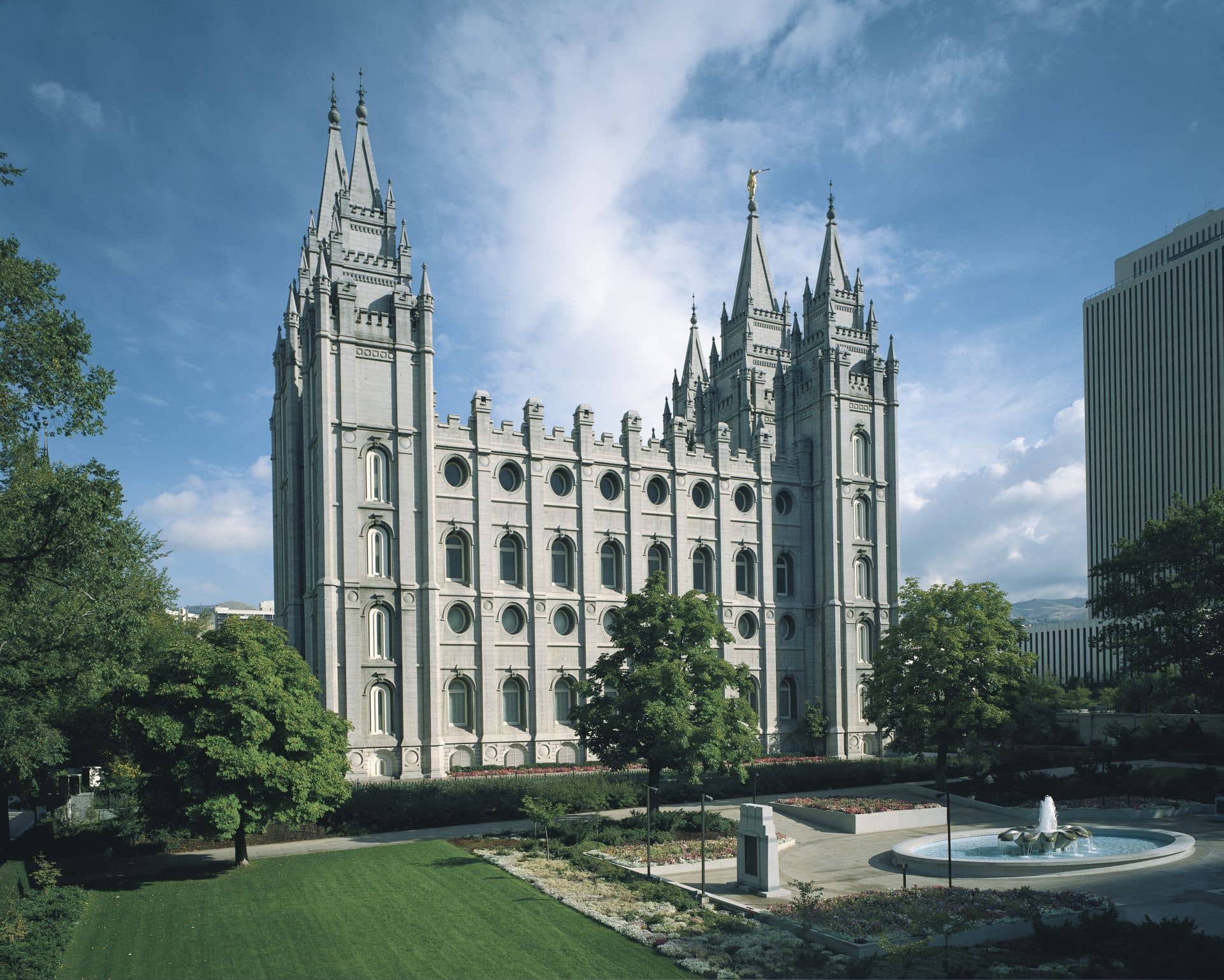 The Salt Lake Temple, a white rectangular building with three tall spires on each short side.