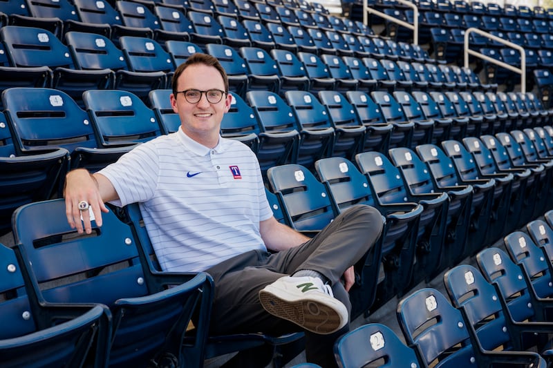 Will Melville, a Latter-day Saint and BYU graduate student, sits in the bleachers at a baseball park.