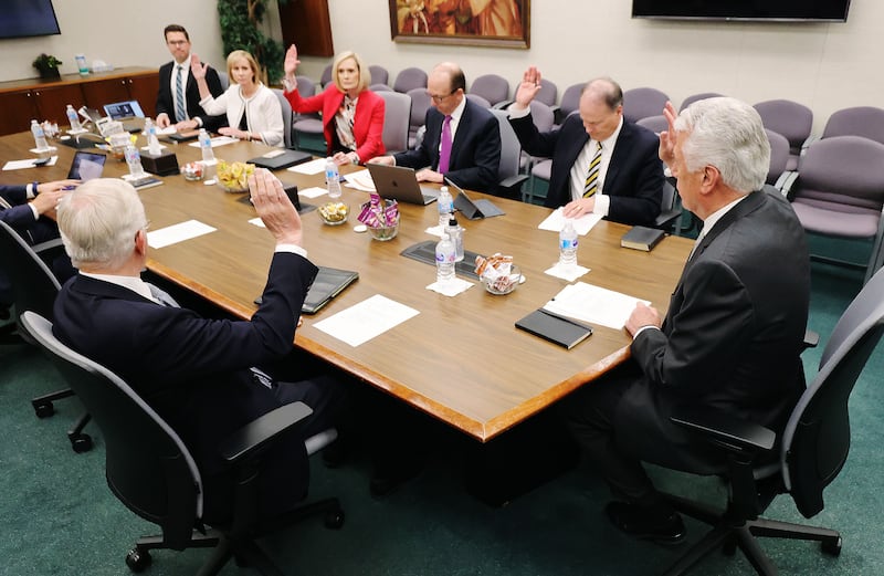 Five members of the Missionary Executive Council sit at a table and raise their hands in a support of an item during a Missionary Executive Council meeting at the Church Office Building in Salt Lake City on Wednesday, May 26, 2021.